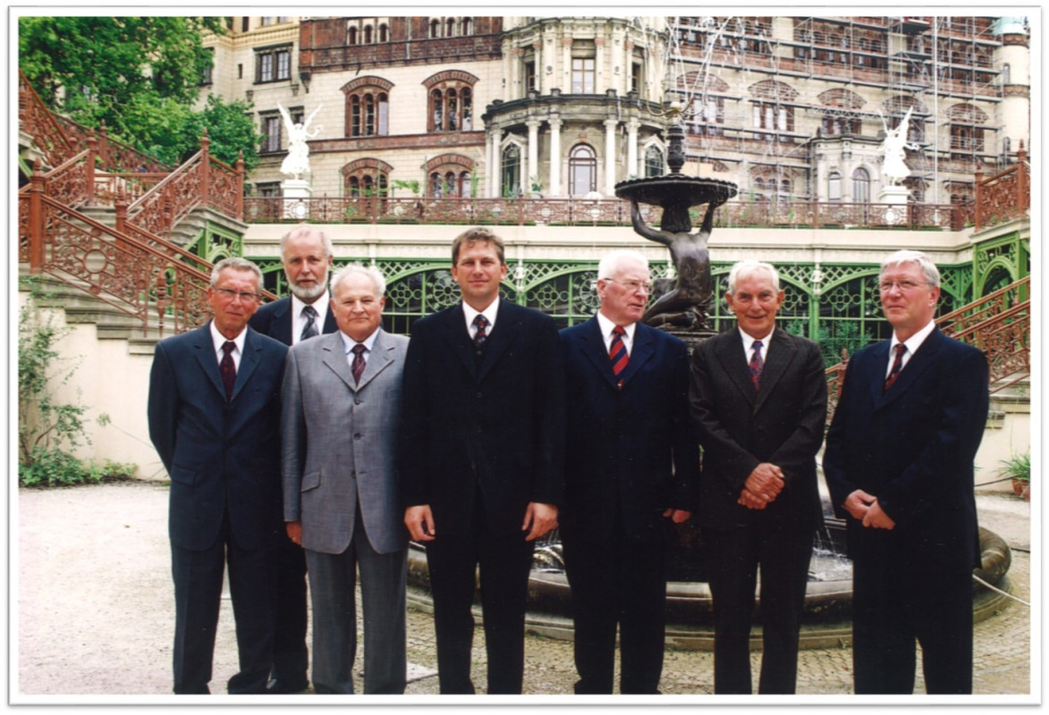 50 jähriges Firmenjubiläum vor dem Schweriner Schloß<br><br><b>Kurt Sonnenberg</b> – Ltr. NL Neustrelitz bis 06/1997; 2. Reihe, <b>Burkhard Sigeneger</b>  – GF FB Brücken 01/1998 - 03/2012; <b>Alfred Katzer</b>  – GF FB Brücken bis 12/1997; <b>Dr.-Ing. Michael Krüger</b>  – Hauptgeschäftsführer 01/1999 - 12/2021; <b>Walter Autrum</b>  – Hauptgeschäftsführer bis 12/1998; <b>Karl Sanftleben</b>  – FB FB Verkehrsanlagen bis 09/1996; <b>Hans-Reiner Puffpaff</b>  – GF FB Verkehrsanlagen 10/1996 - 08/2008<p>